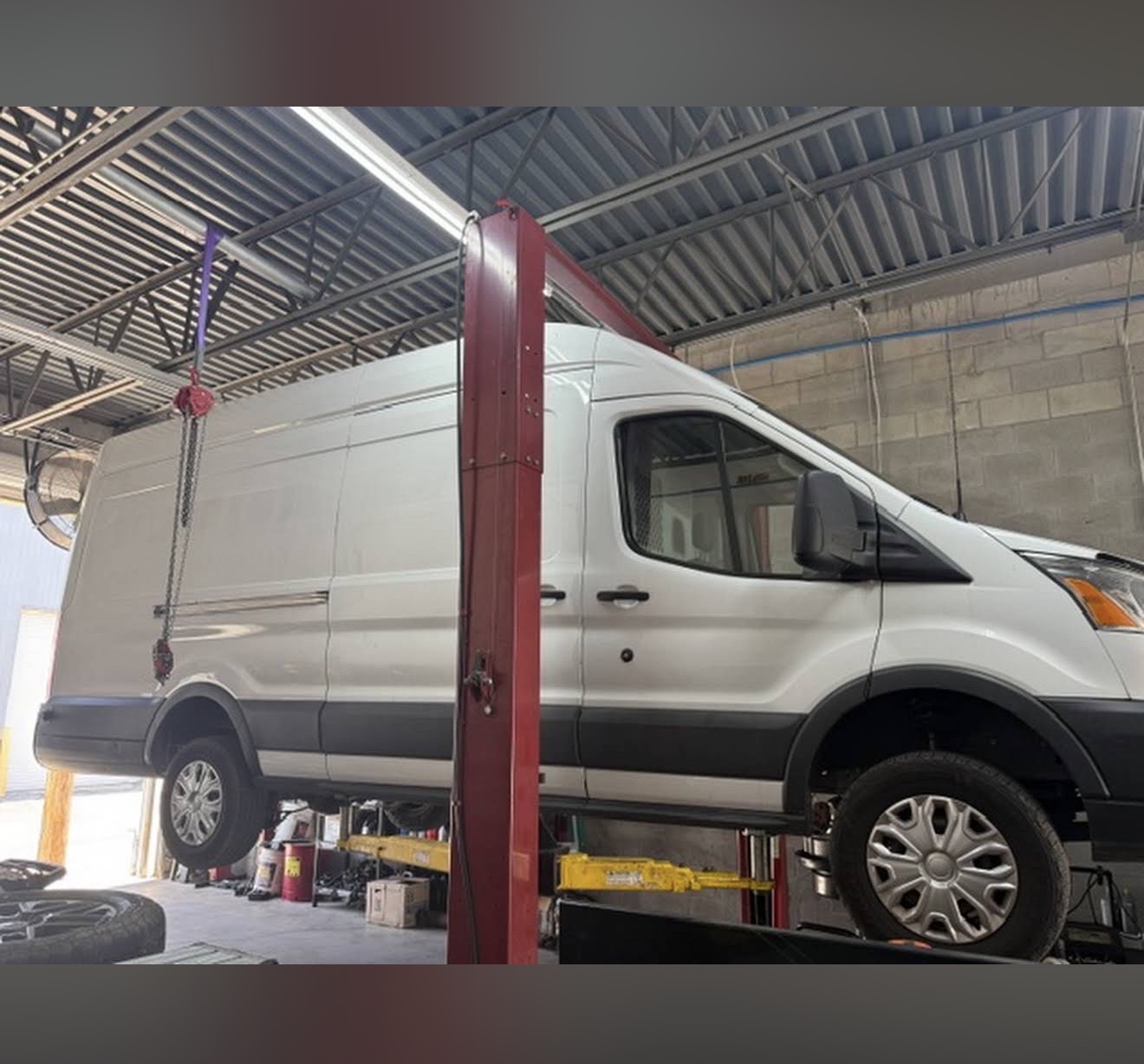 Commercial work van being serviced on a lift at Adrian’s Auto Repair