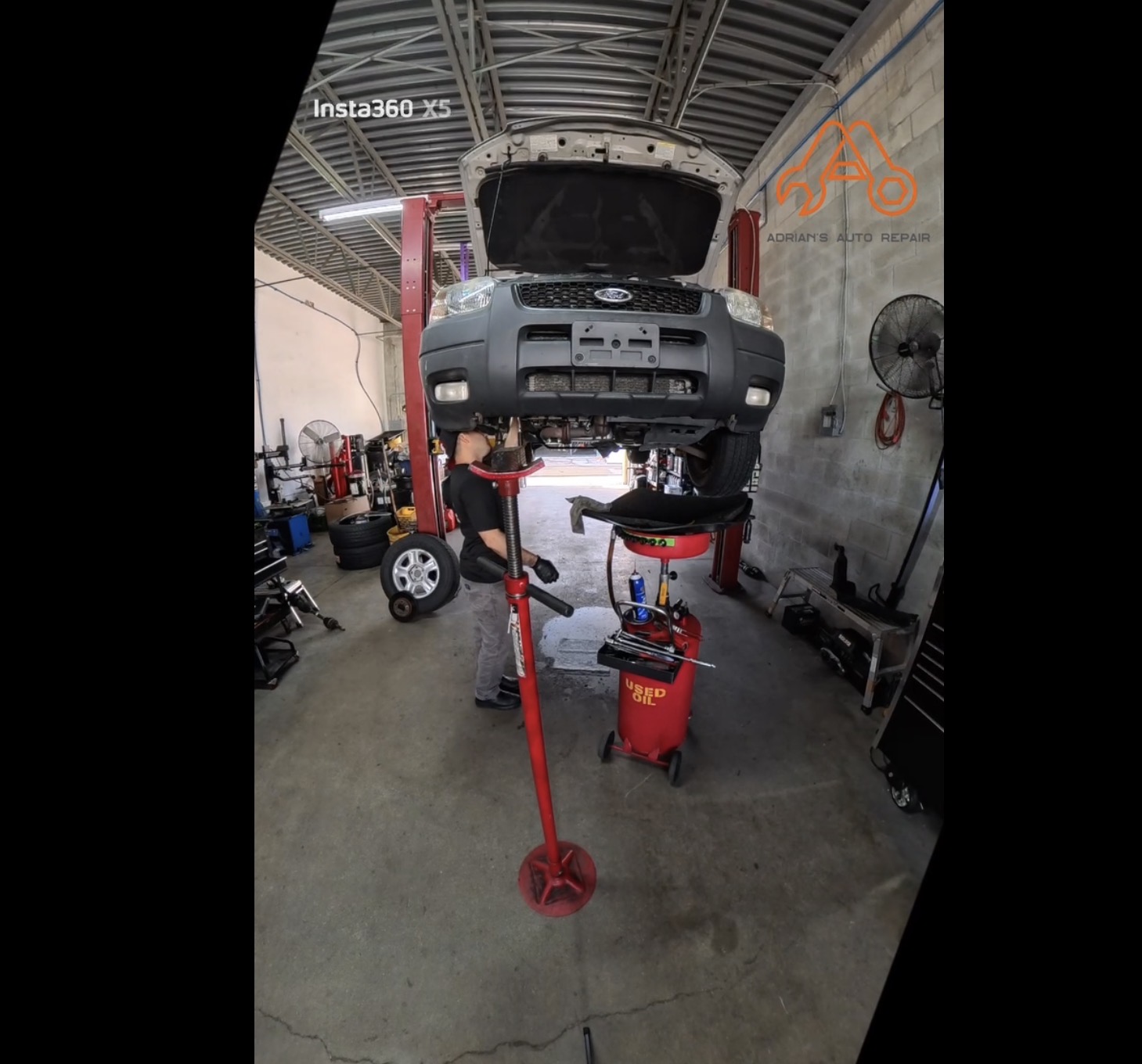 Vehicle on a lift being serviced inside Adrian’s Auto Repair